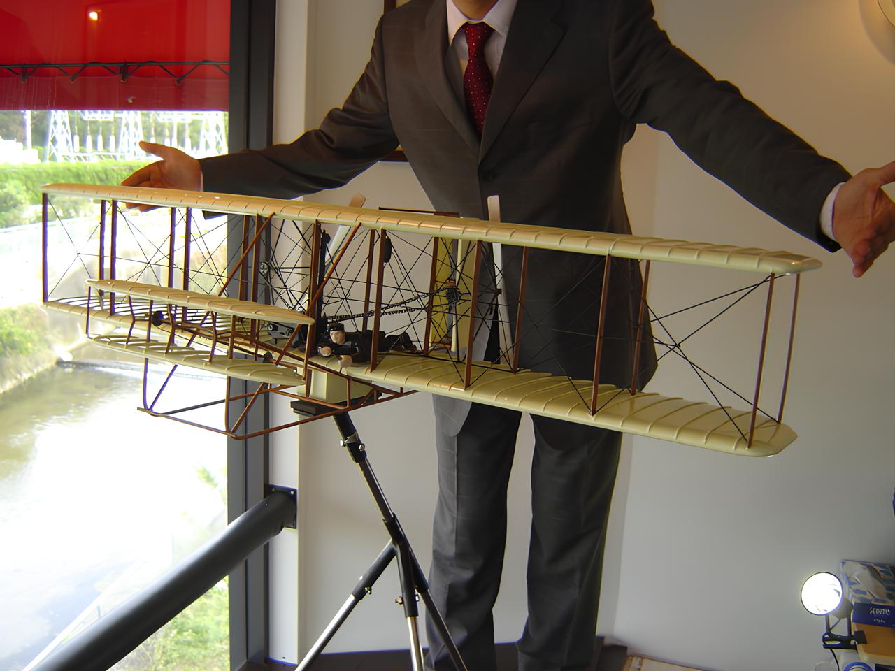 過去制作実績の飛行機と一緒にならぶ経営者